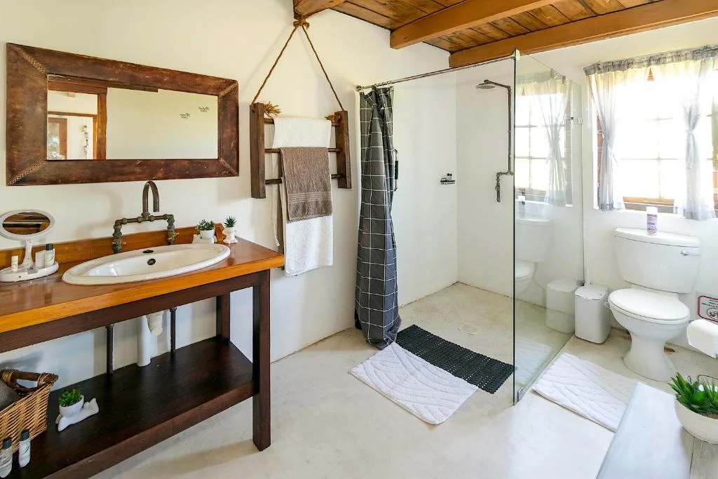 Spacious bathroom with wooden vanity, walk-in shower, and natural light