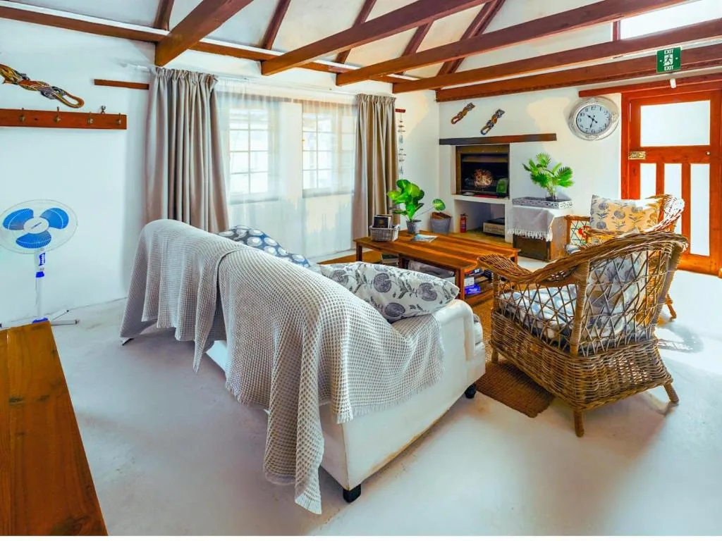 Spacious bedroom with bed, fireplace, and wicker seating area