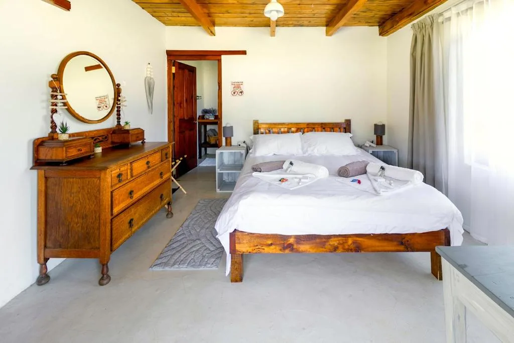 Spacious bedroom with twin wooden beds and antique dresser mirror