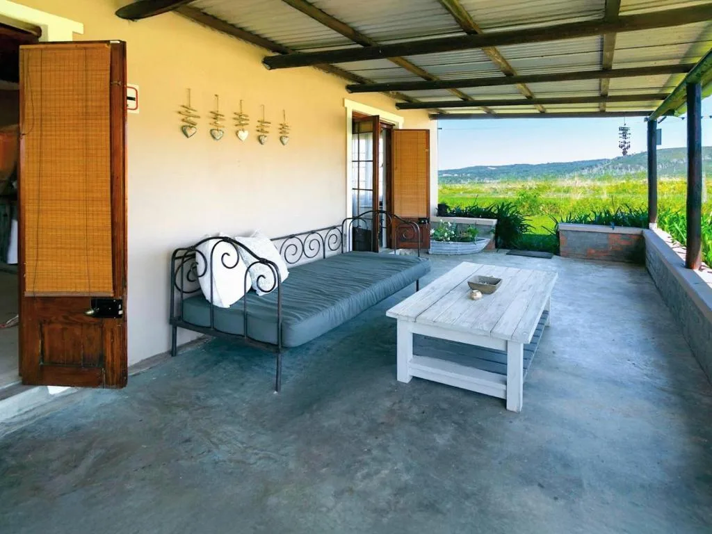 Covered deck with bed, table, and expansive mountain valley views
