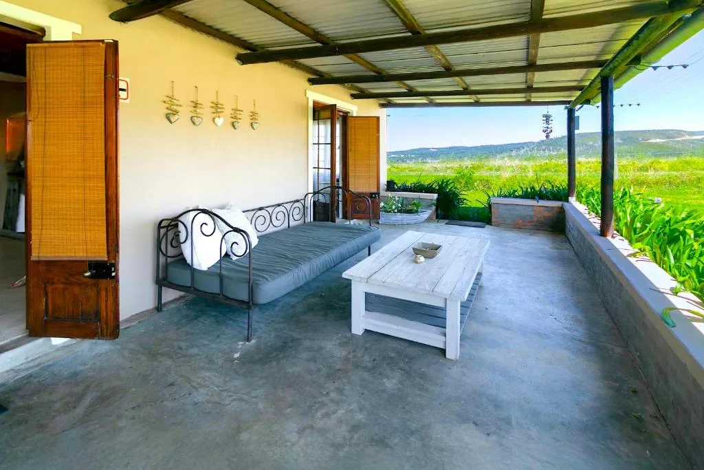 Covered patio with bed, table, and mountain view beyond