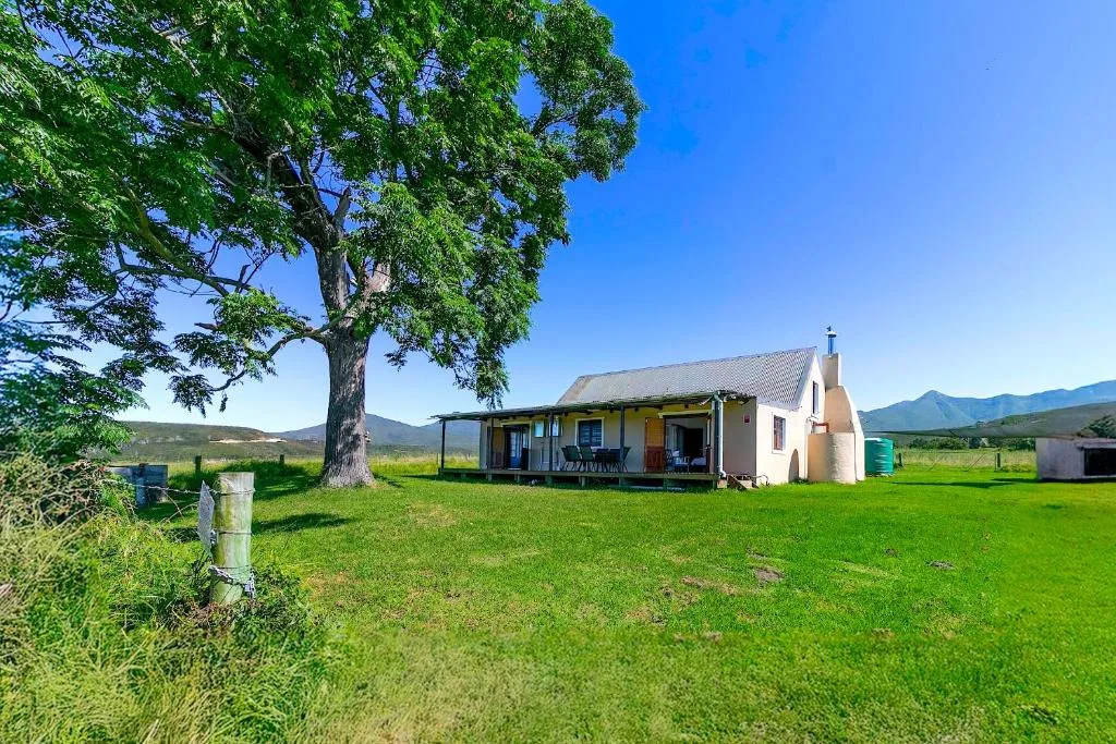Charming cottage with covered porch set in lush green valley meadow