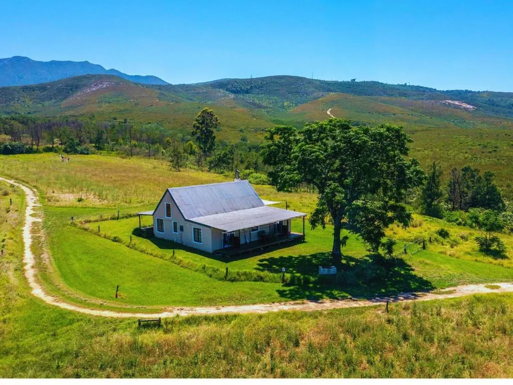 Charming cottage nestled in lush valley with mountains backdrop