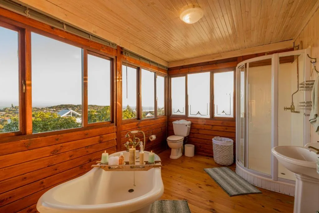 Luxurious bathroom with freestanding tub, wooden beams, panoramic windows overlooking Sedgefield