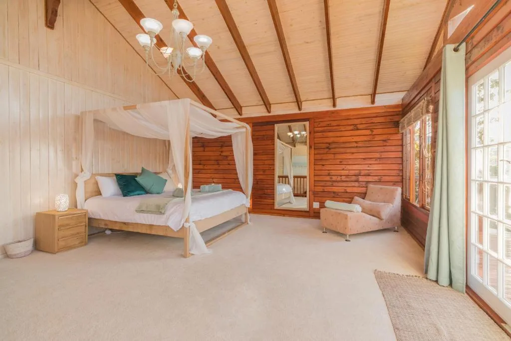 Spacious bedroom with four-poster canopy bed and wooden beams