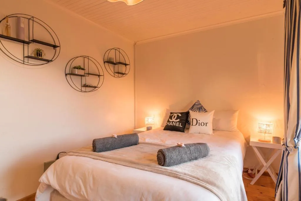 Bright bedroom with white bedding, designer pillows, and circular wall shelves