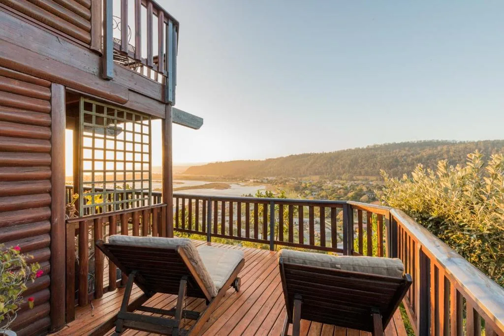 Wooden deck with loungers overlooking lagoon and forested hills