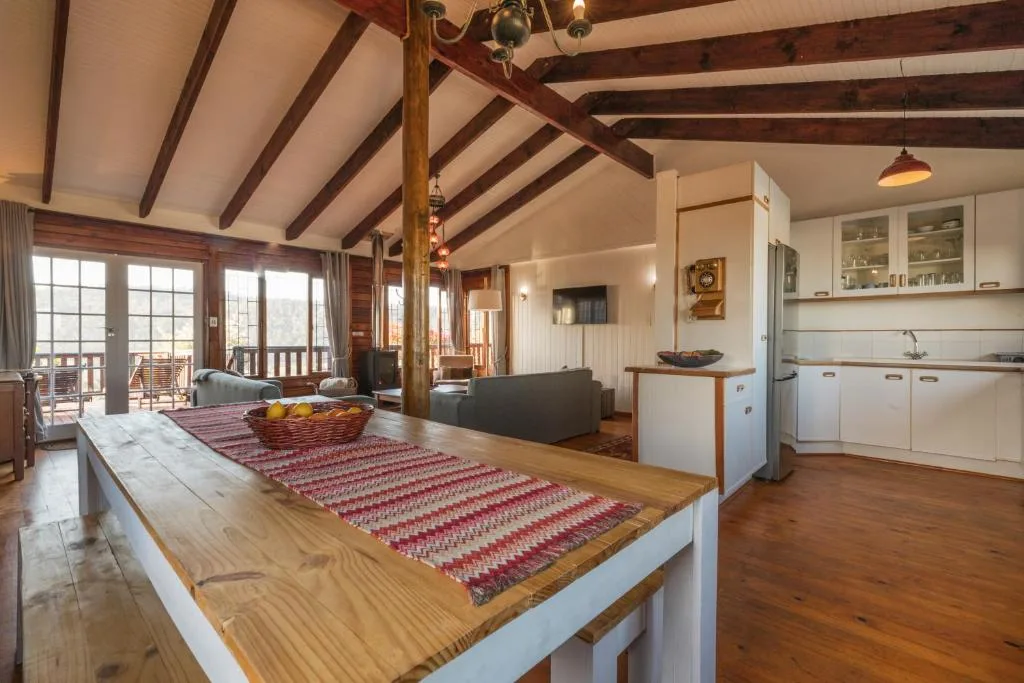 Open-plan kitchen and lounge with wooden beams and rustic decor