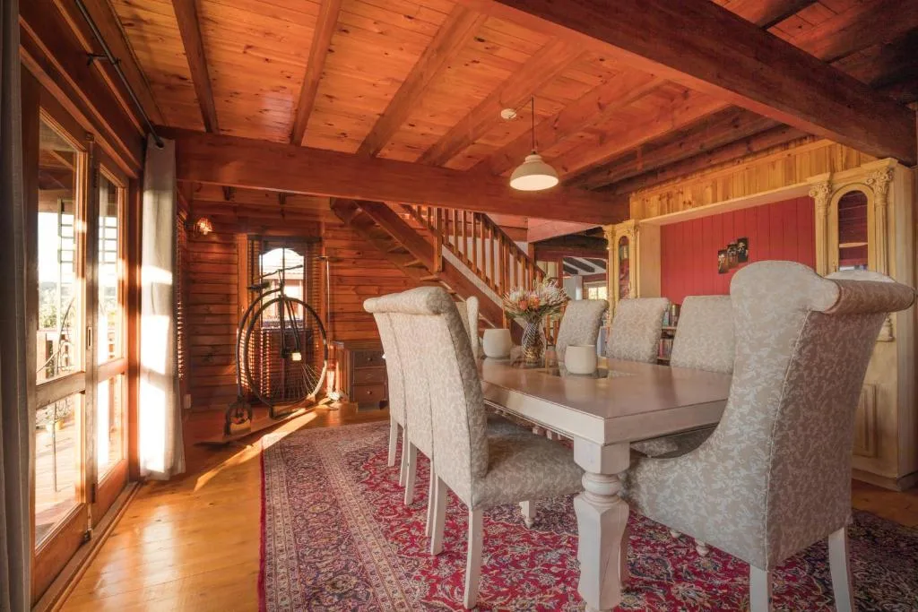 Wooden dining room with upholstered chairs and rustic beamed ceiling
