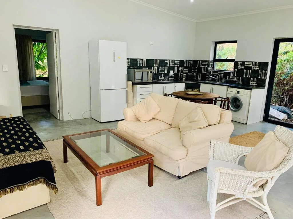Open-plan lounge with cream sofa, coffee table, and wicker chairs