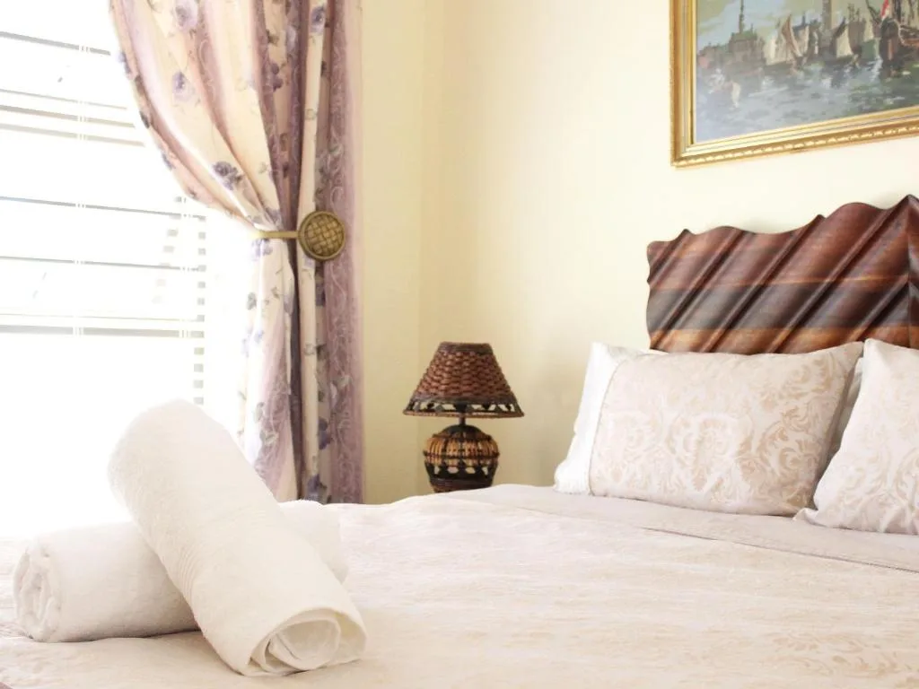 Elegantly decorated bedroom with leather headboard and crisp white linens