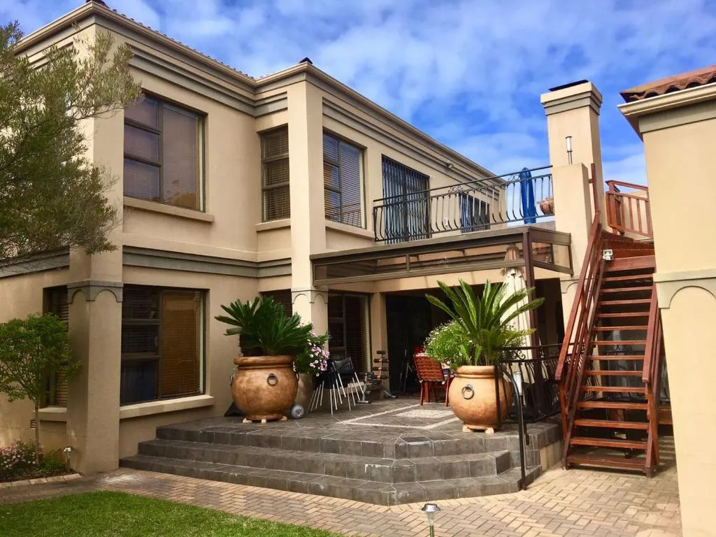 Cream facade with terracotta pots and furnished outdoor patio area