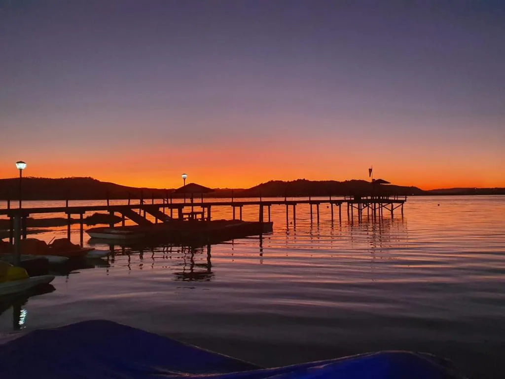 Stunning sunset over tranquil lagoon with wooden jetties and boats