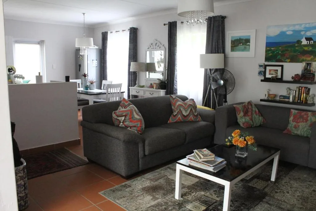 Open-plan lounge with dark sofa, patterned cushions, and coffee table