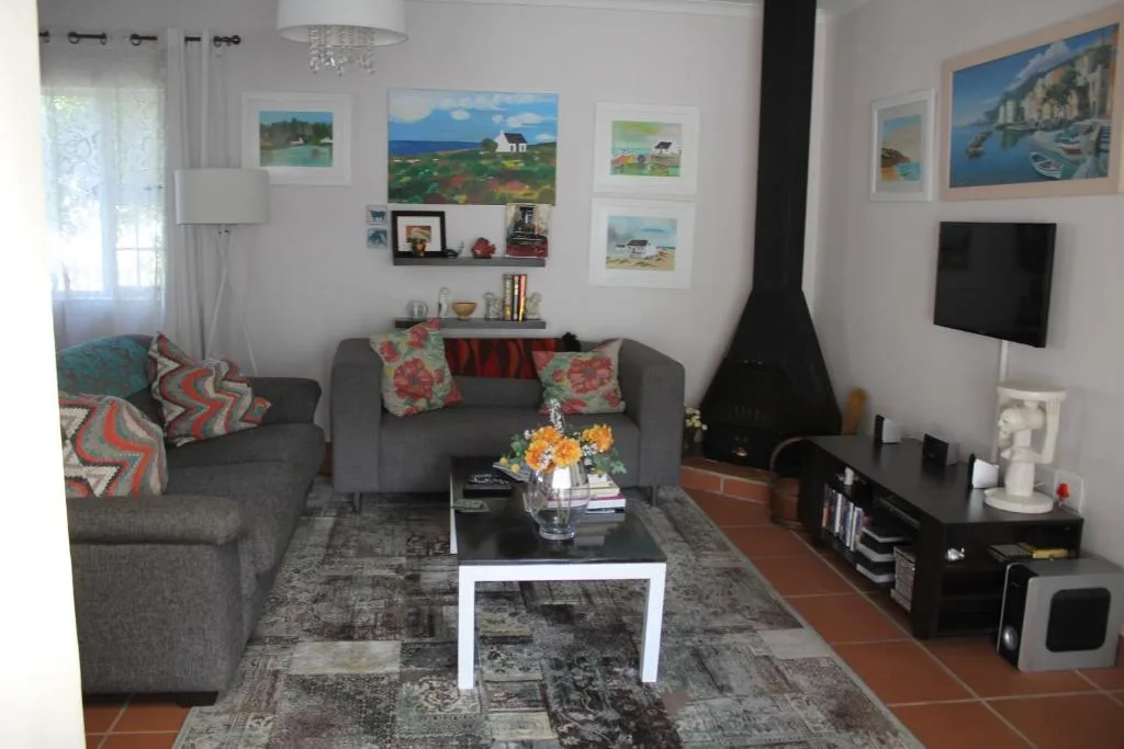 Spacious living room with gray sofas, colorful cushions, and wall art