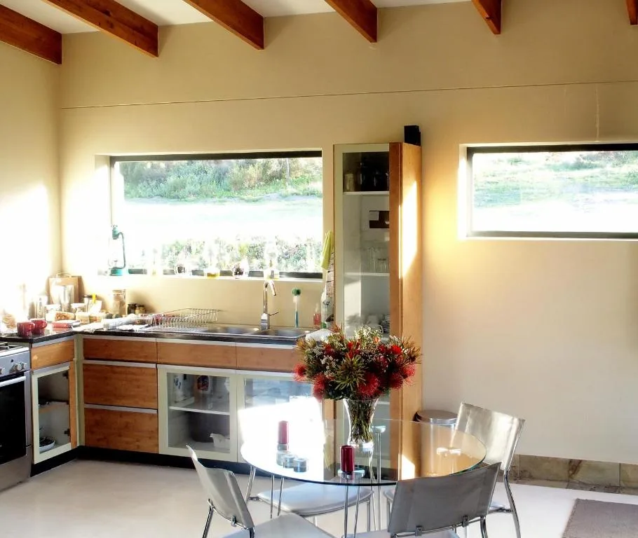 Modern kitchen with wooden cabinetry, stainless steel sink, and water views through windows