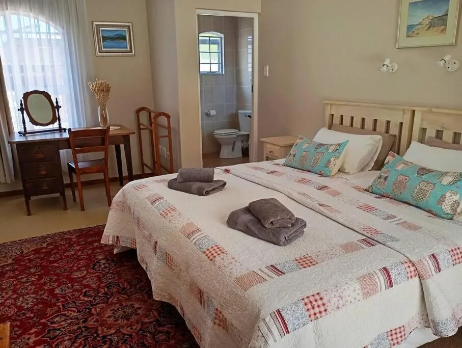 Spacious bedroom with two beds, wooden furniture, and en-suite bathroom access