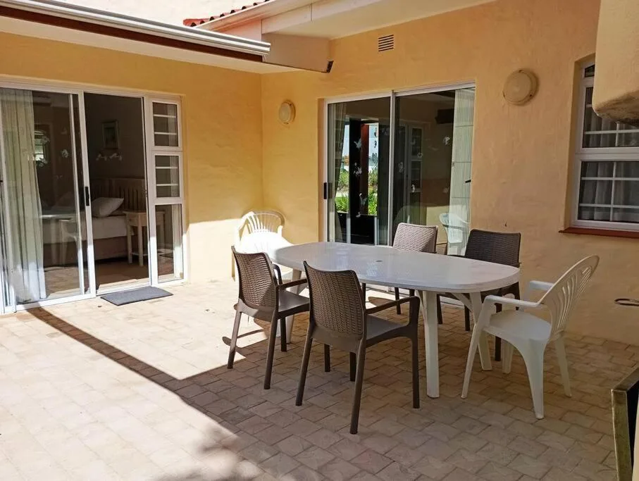 Patio dining area with table and chairs overlooking garden