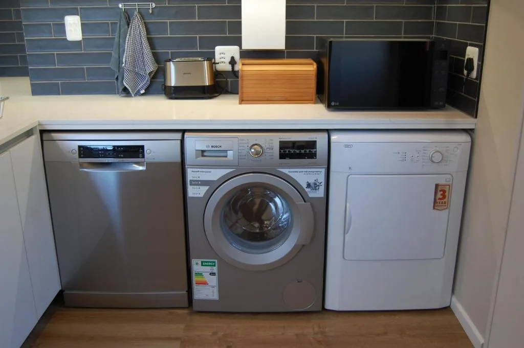 Laundry area with dishwasher, washing machine, and tumble dryer