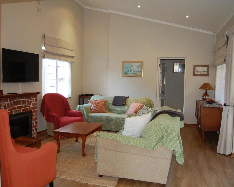 Bright living room with fireplace, sofas, and armchairs arranged around coffee table