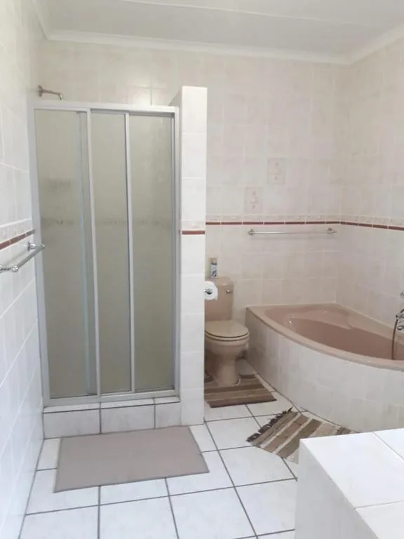 Spacious bathroom with shower enclosure, bathtub, and toilet