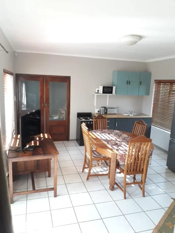 Open-plan dining and kitchen area with wooden table and chairs