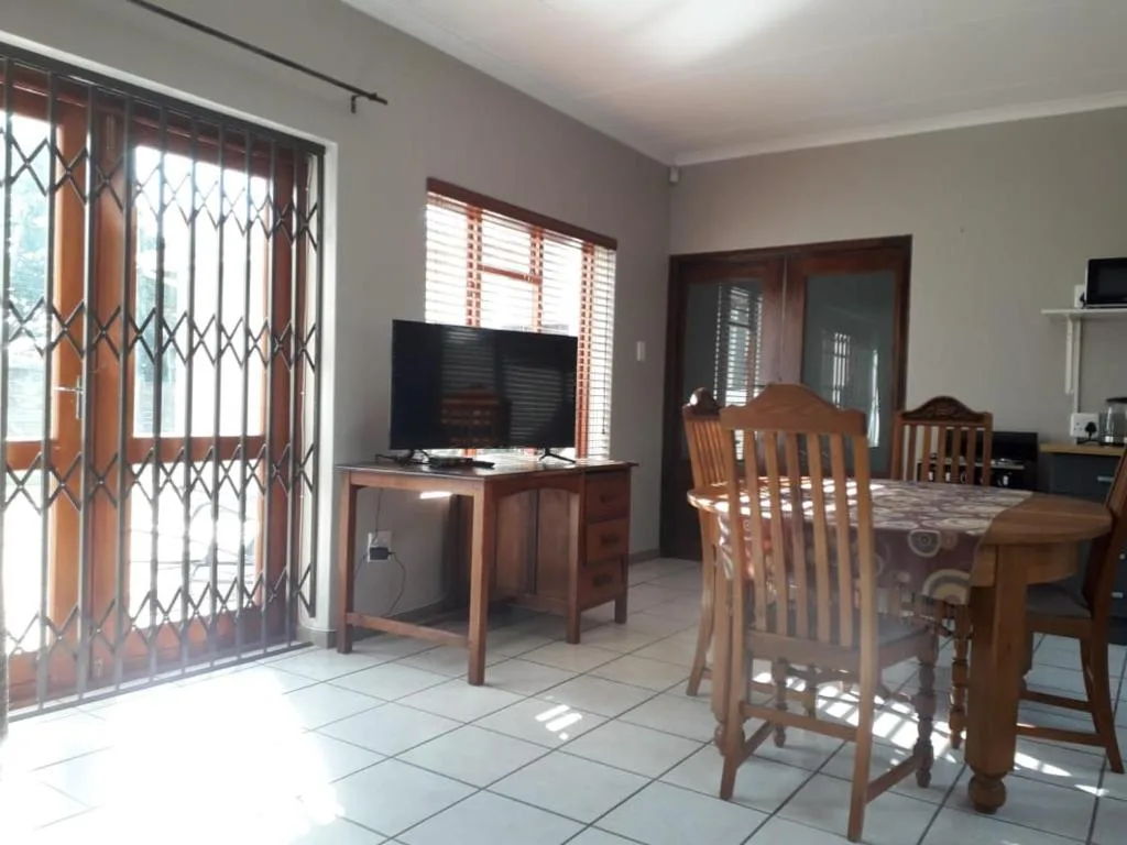 Open-plan living area with dining table, TV stand, and security gates