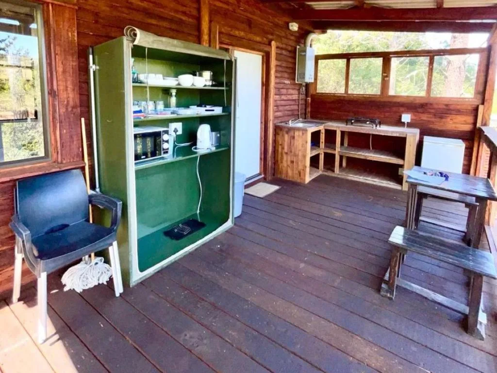 Wooden deck interior with green kitchenette unit and rustic furnishings