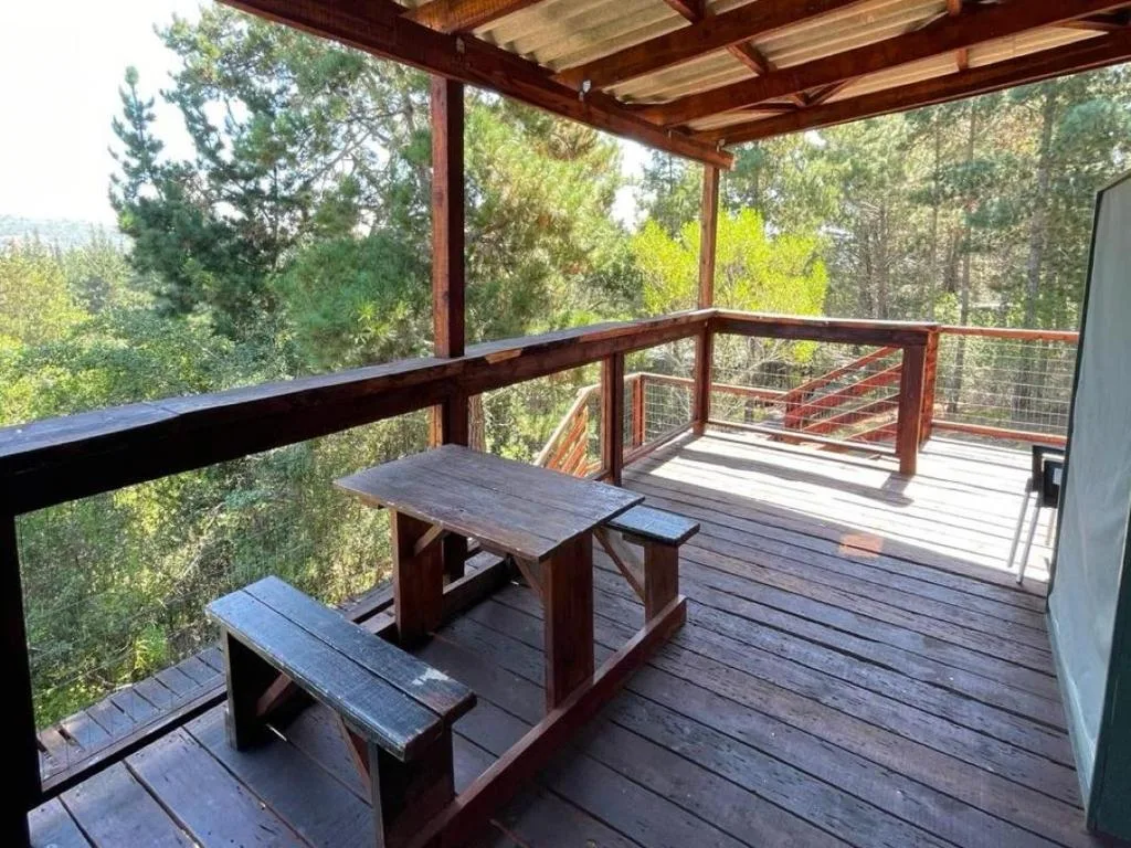 Wooden deck with picnic table overlooking forested valley landscape