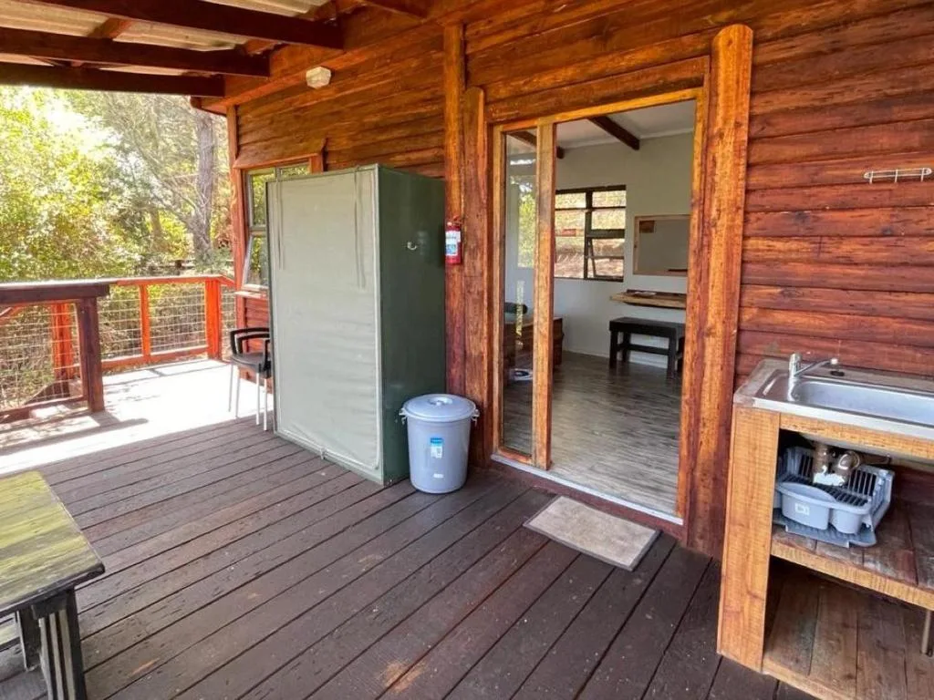 Wooden deck with outdoor shower and rustic log cabin entrance doors