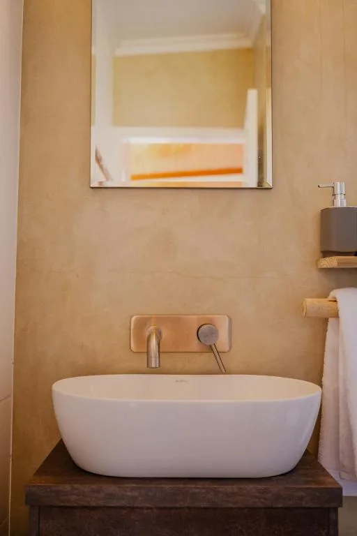 Modern bathroom with oval white basin sink and wall-mounted fixtures