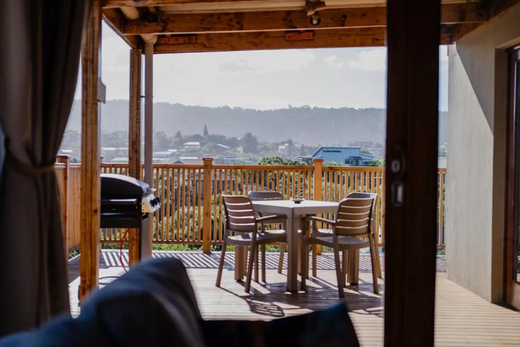 Wooden deck with dining table, chairs, and scenic mountain views beyond