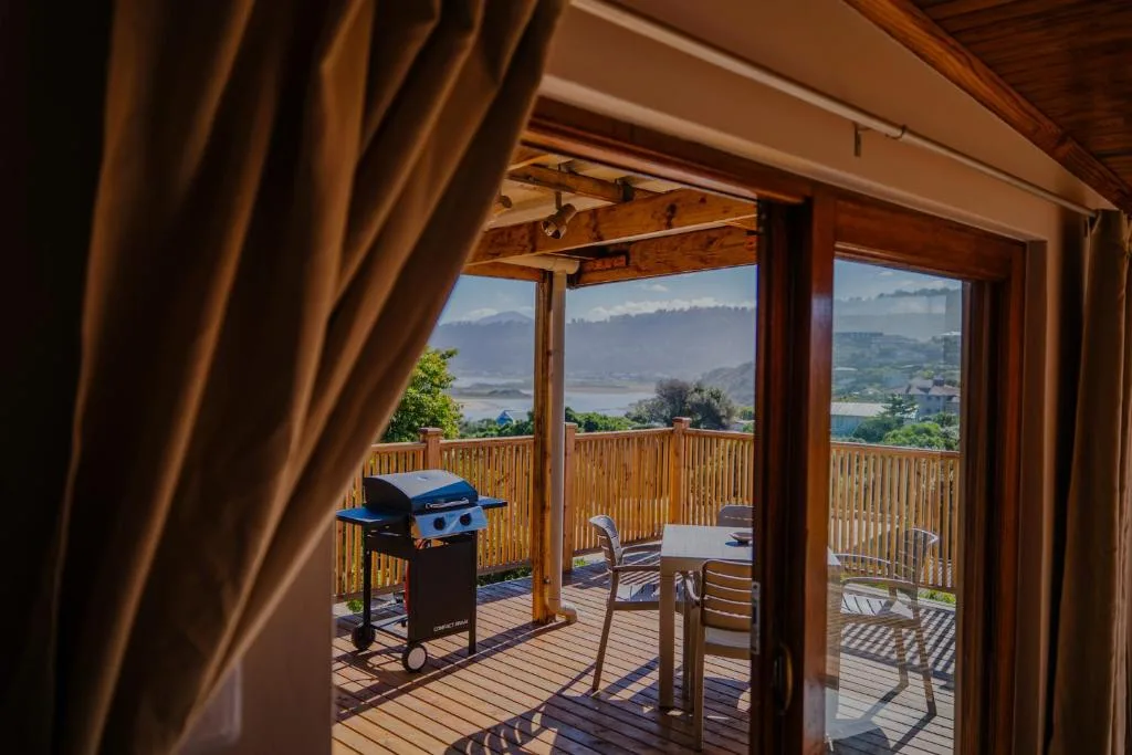 Wooden deck with braai grill and mountain valley views through open doors