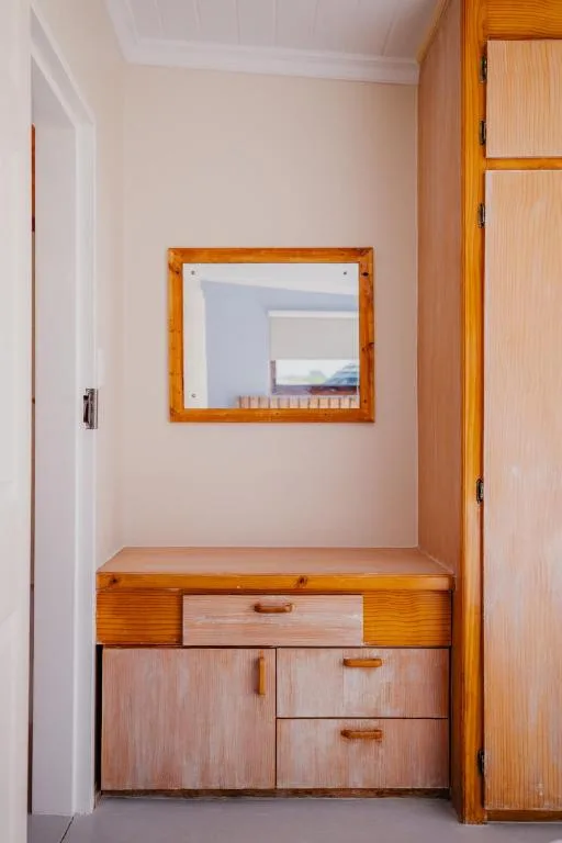 Wooden vanity with mirror in bright, minimalist bedroom alcove