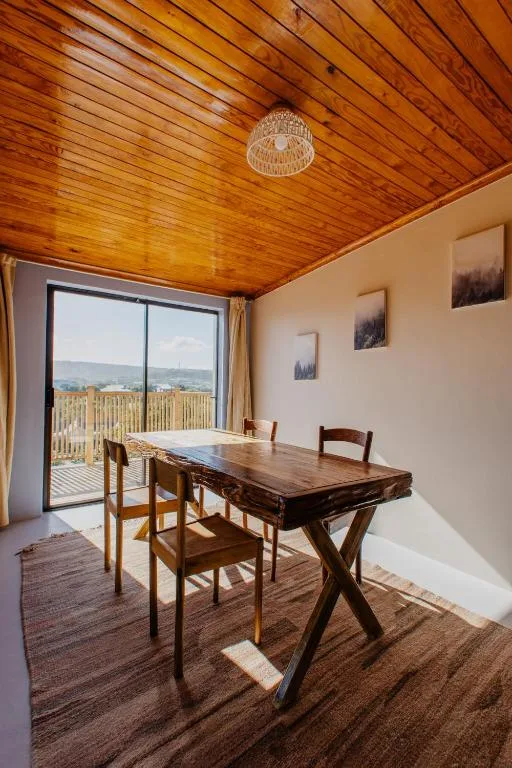 Wooden dining table with chairs overlooking mountain views through glass doors