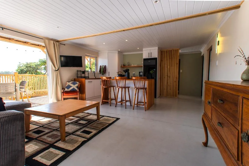 Open-plan living area with sofa, wooden coffee table, and kitchen island seating