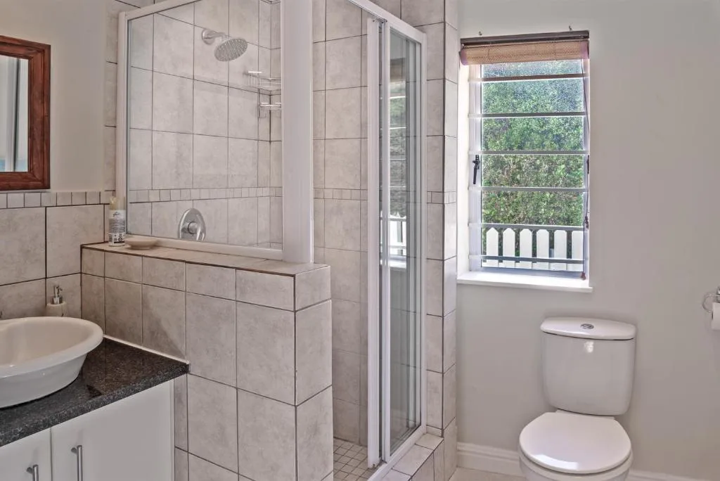 Spacious bathroom with shower cubicle, vanity basin, and toilet