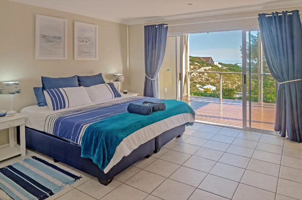 Spacious bedroom with queen bed, ocean and garden views through sliding doors