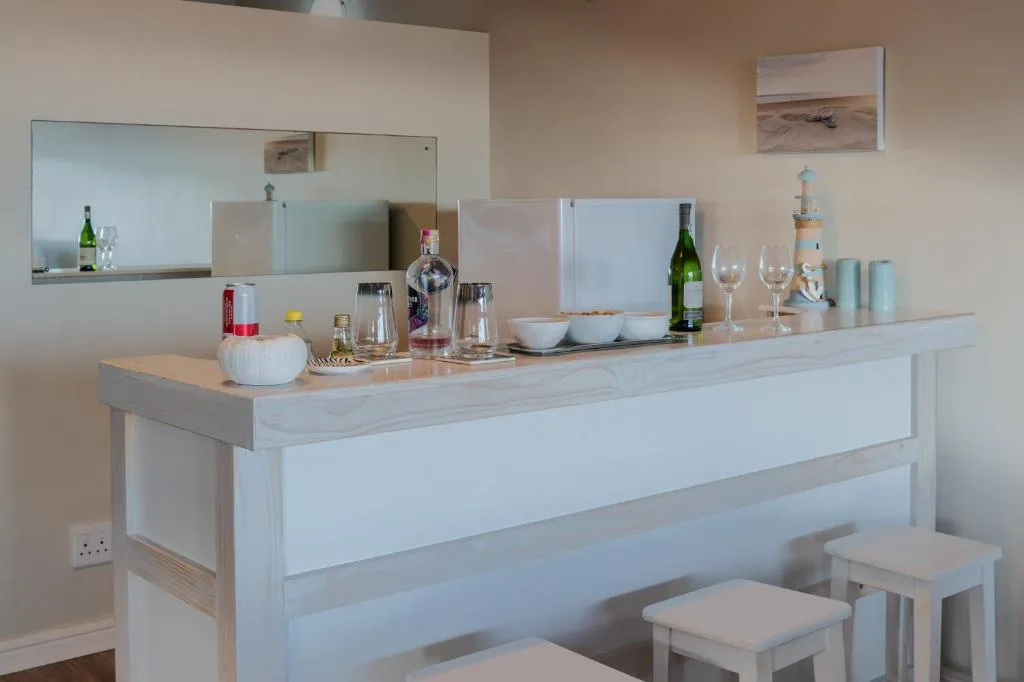 Modern kitchen bar with wine glasses, bottles, and decorative tableware display
