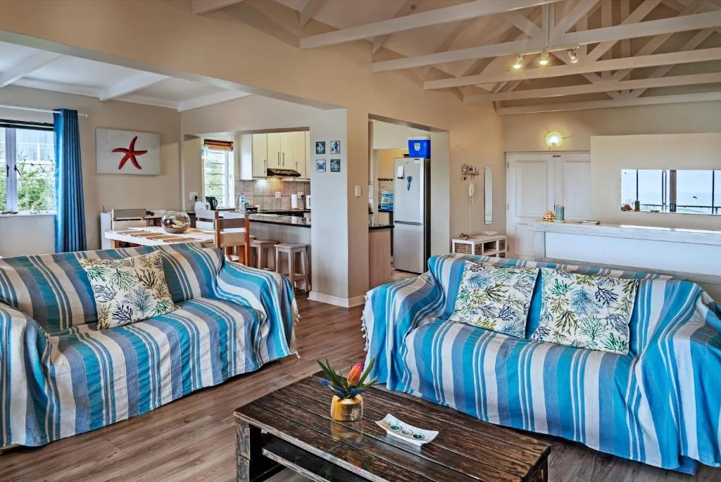 Open-plan lounge with two blue striped sofas and exposed ceiling beams