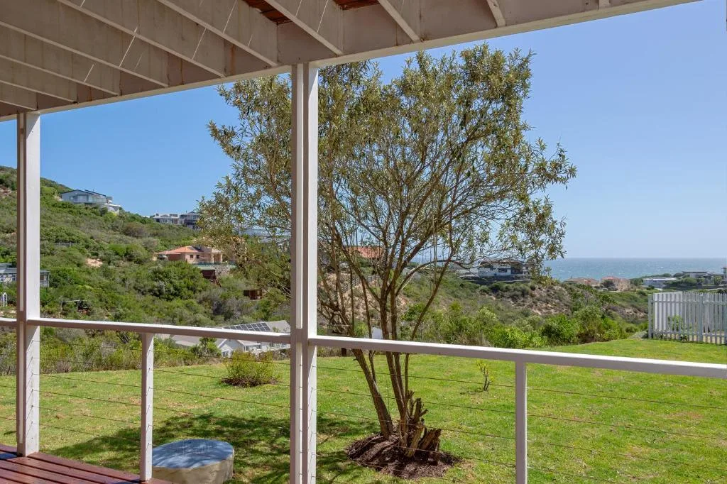 Scenic coastal vista with lagoon and hills from shaded deck area