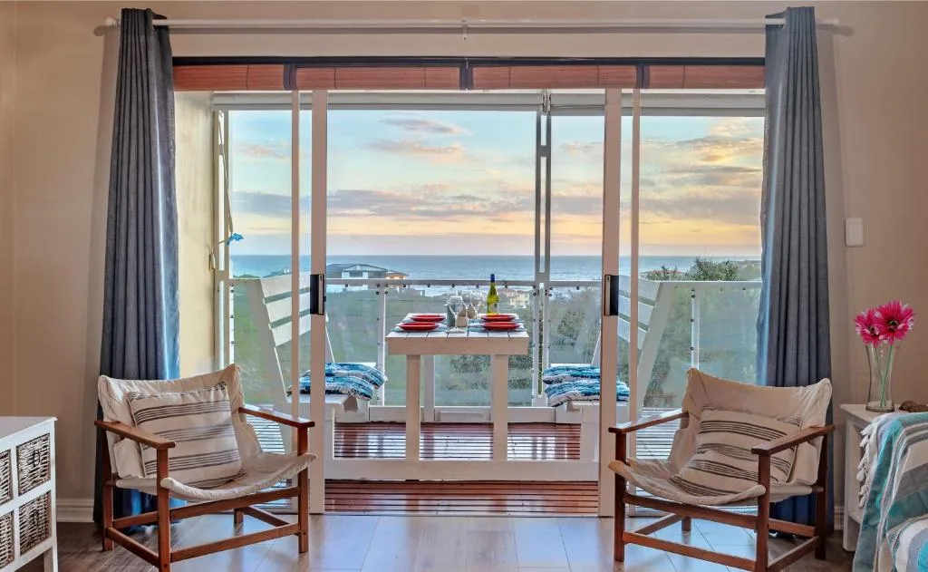 Ocean sunset view through large sliding doors and windows from interior