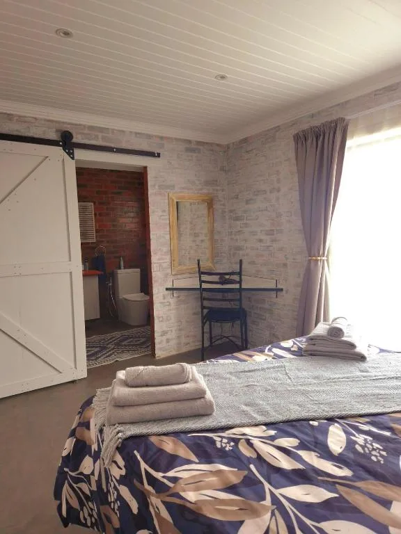 Spacious bedroom with bed, desk, and ensuite bathroom entrance