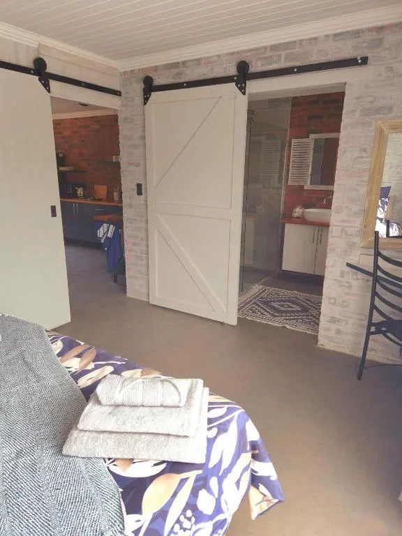 Spacious bedroom with sliding barn doors, brick walls, and modern furnishings