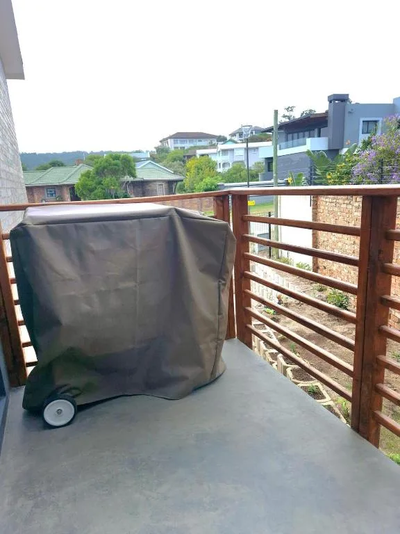 Covered braai grill on wooden deck with neighborhood views