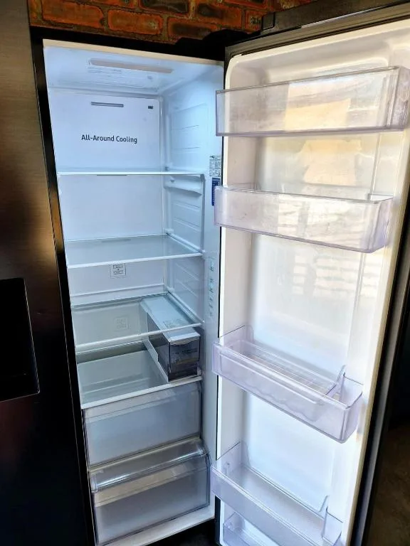 Open refrigerator with all-around cooling feature, empty shelves and drawers