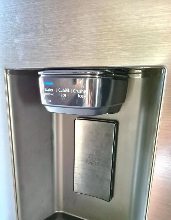 Stainless steel refrigerator with water and ice dispenser on wooden flooring