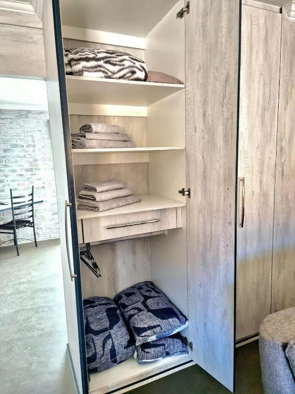Open linen closet with shelves of neatly folded towels and bedding