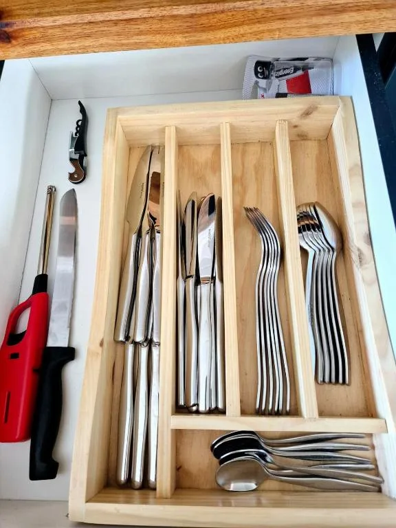 Organized wooden drawer with neatly arranged cutlery and kitchen utensils