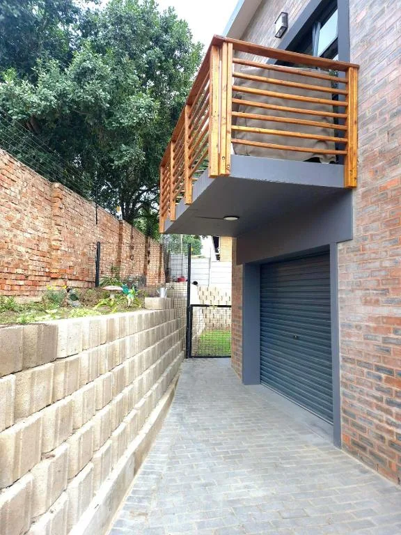 Modern brick building with wooden deck railing and garage entrance